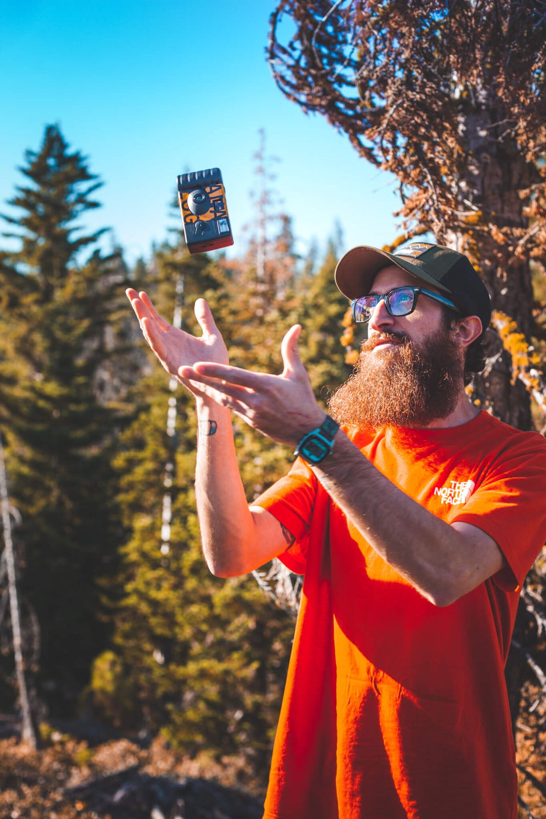 Tossing an Analog disposable camera in the air outdoors